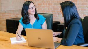 Two professionals reviewing financial records together on a laptop, discussing cryptocurrency tax reporting