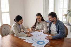 A financial advisor reviewing documents and charts with a couple at a table