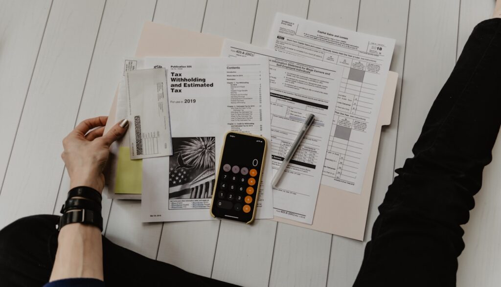 Tax return forms and a calculator spread out on a desk being reviewed