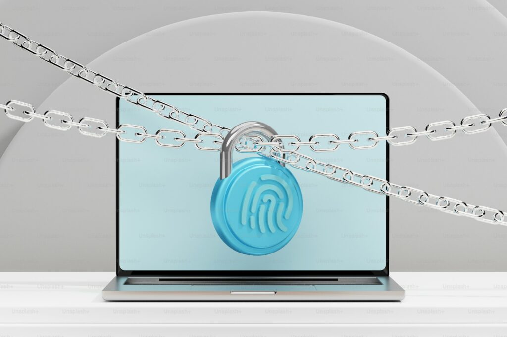 Laptop computer secured with a padlock and chain, representing data security and fraud protection